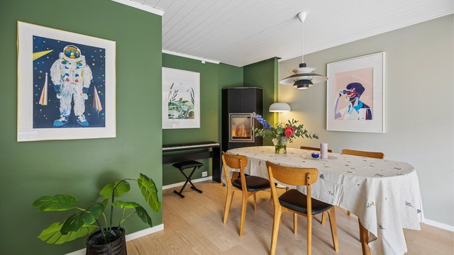 Spisestuen er en naturlig del av oppholdsrommet, med nærhet til både kjøkken og peis.