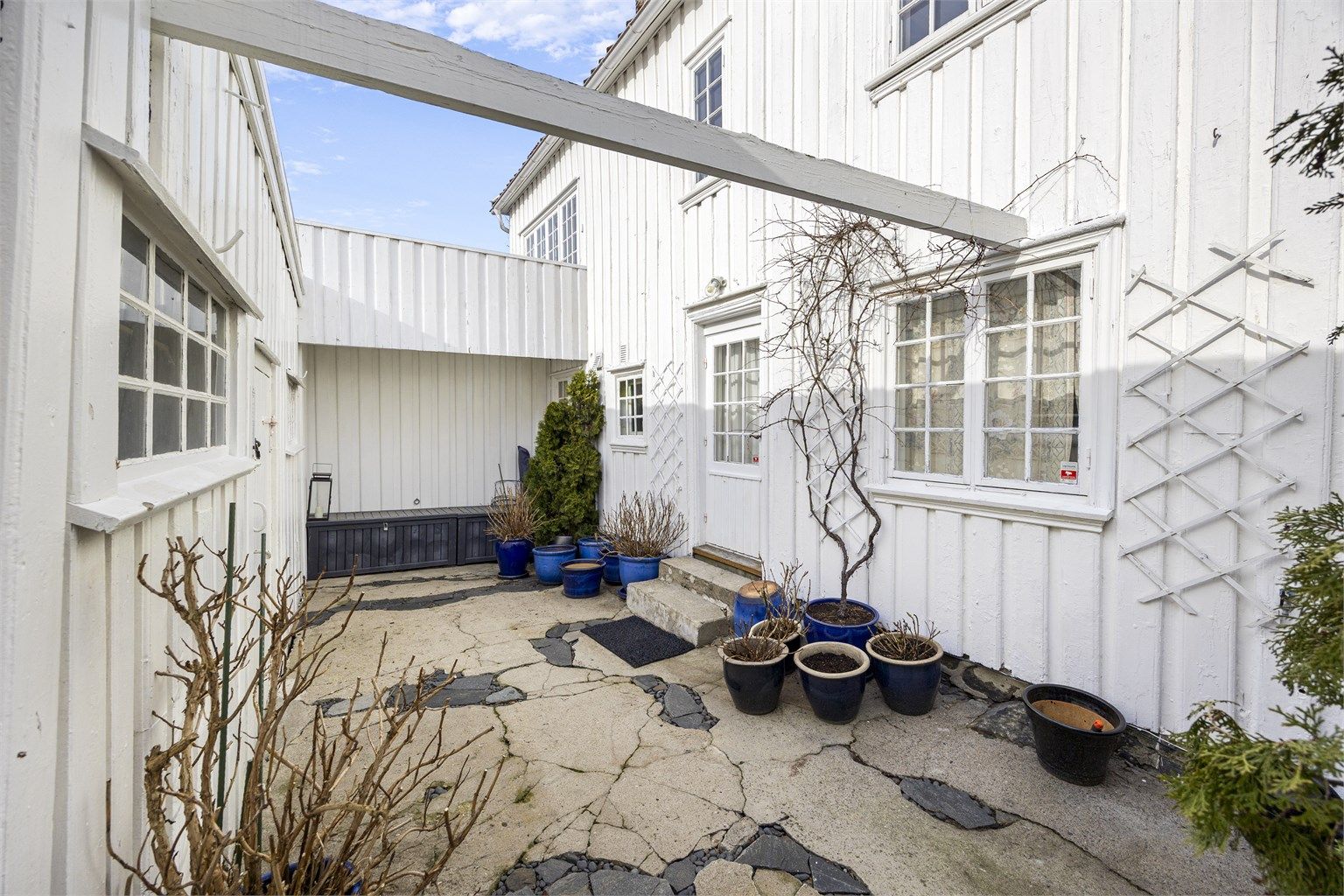 Bakgården som binder opprinnelig del og tilbygg sammen. Det er god oppbevaringsplass i boligen med flere boder. 