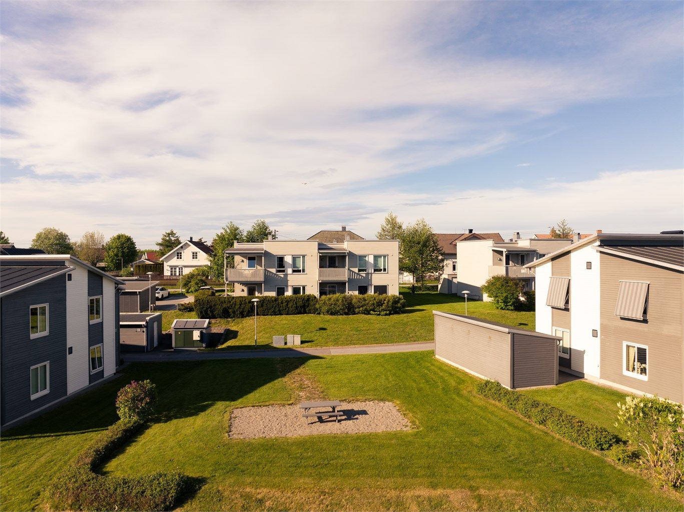 Leiligheten er én av totalt åtte i Solenga Borettslag. I det umiddelbare nabolaget er det fine grøntarealer og benker å sette seg ned på.
