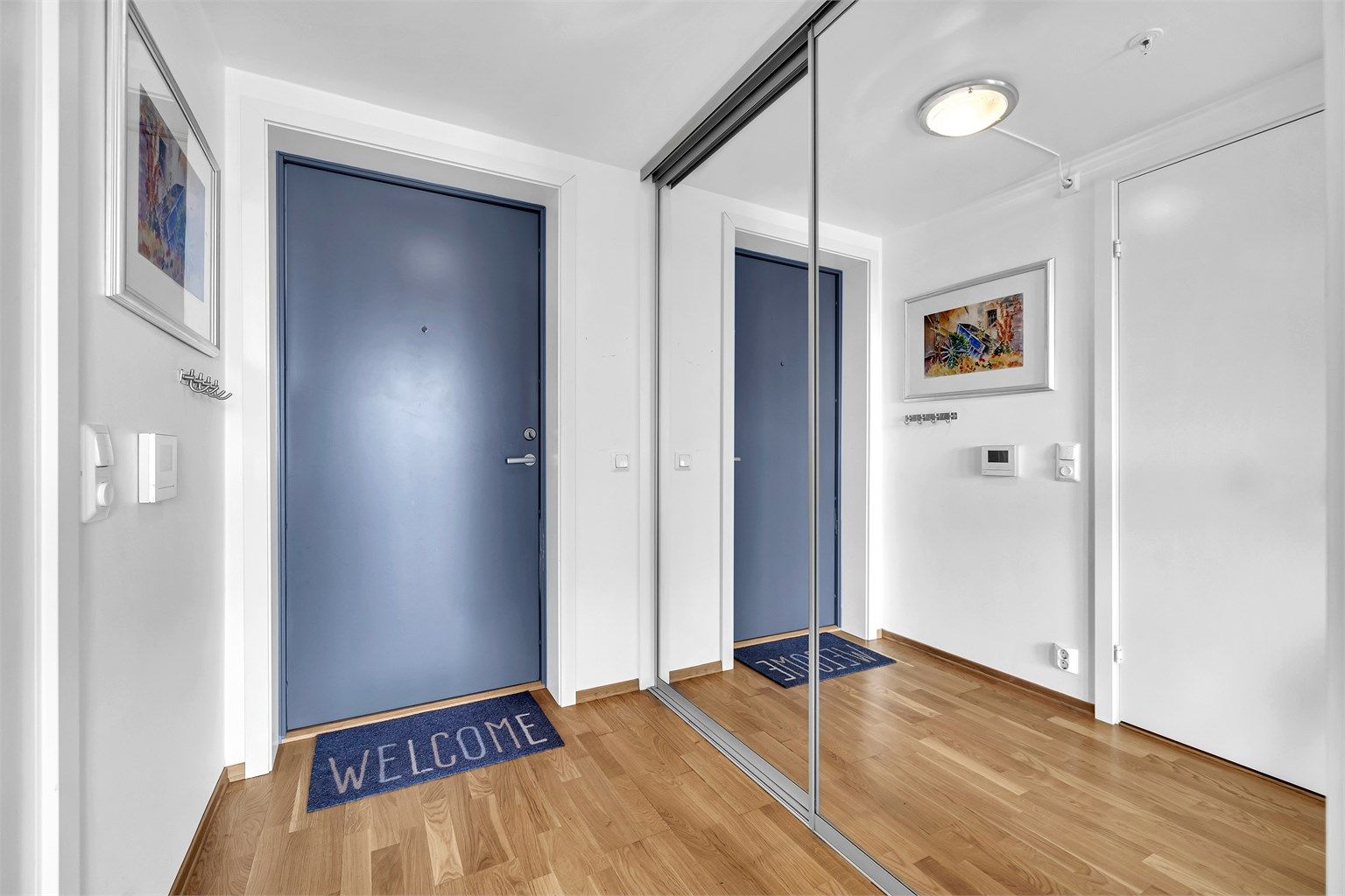 Lun entré med plass til å henge fra seg klær og sette fra seg sko. Praktisk skyvedørsgarderobe.