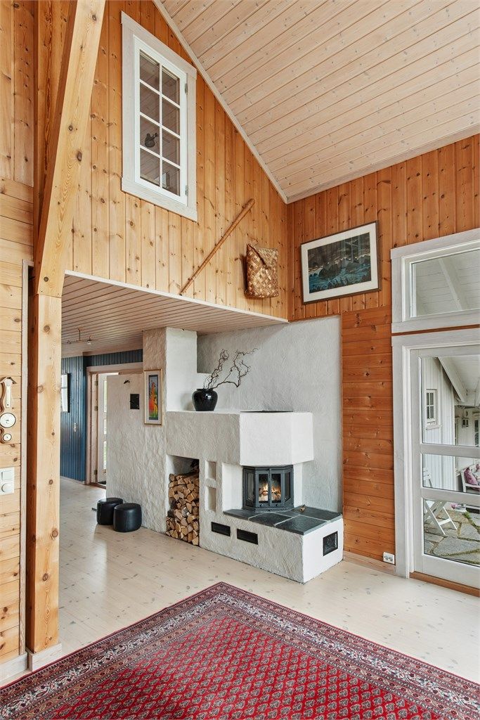 Den plassbygde peisen har to brennkamre. Brennkammeret som vender mot spisestuen bidrar også til oppvarming av det vannbårne systemet når det fyres med ved.