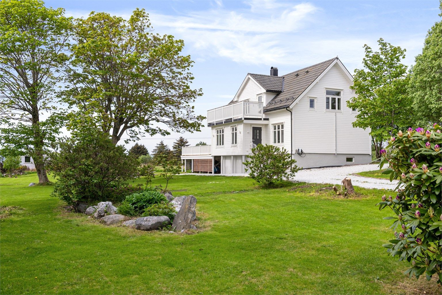 Stor hage med plen og etablert beplantning gir gode muligheter for lek og dyrking.
