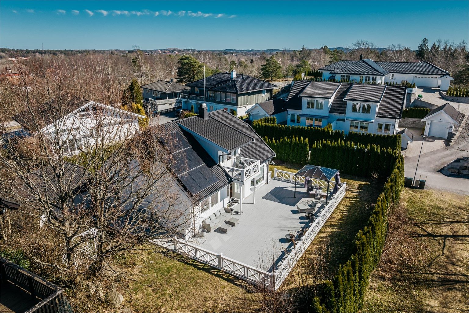 Tomten er omkranset av en tett hekk som skaper en privat og usjenert hage.