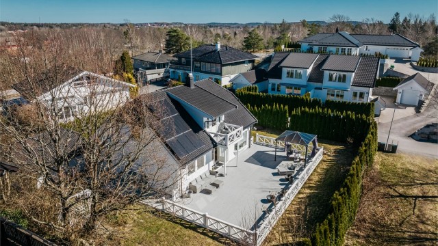 Tomten er omkranset av en tett hekk som skaper en privat og usjenert hage.