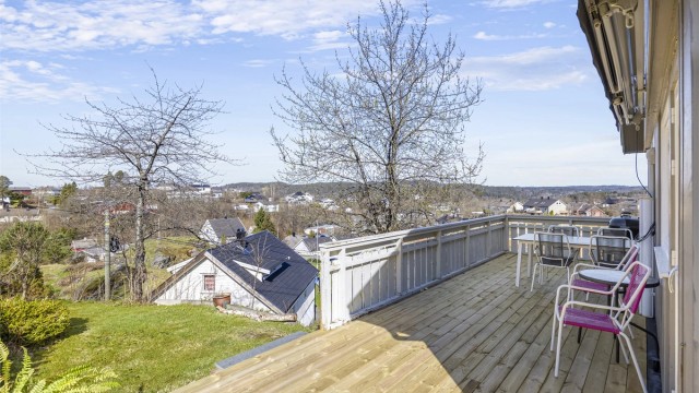 Terrassen strekker seg langs siden av huset og gir gode solforhold.