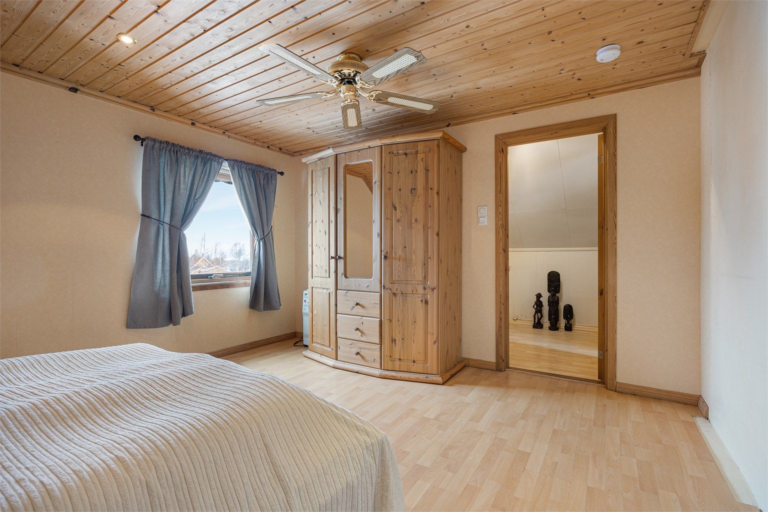 Rommet har laminat på gulvet og panelbord i himlingen.