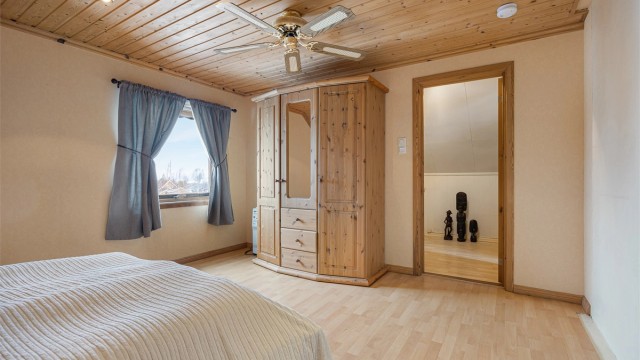 Rommet har laminat på gulvet og panelbord i himlingen.