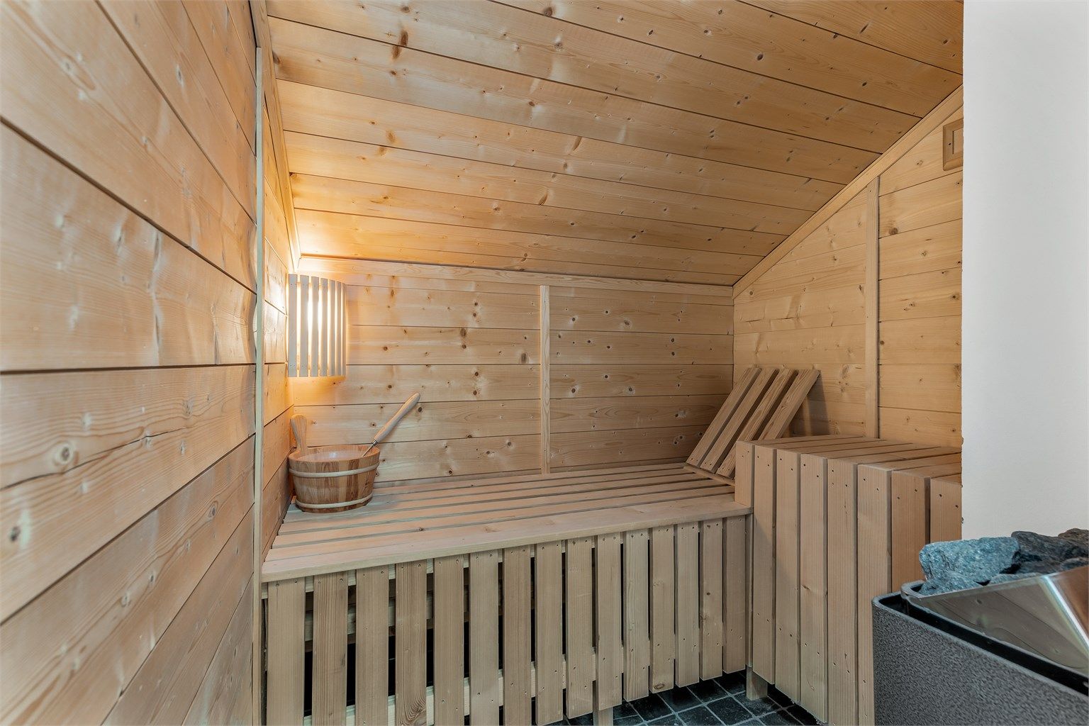 Badstue med tilgang fra badet i 2.etasje. Flislagt gulv. Vegger med trekledning. Himling med trekledning. Naturlig avtrekksventil på vegg. Elektrisk badstueovn.