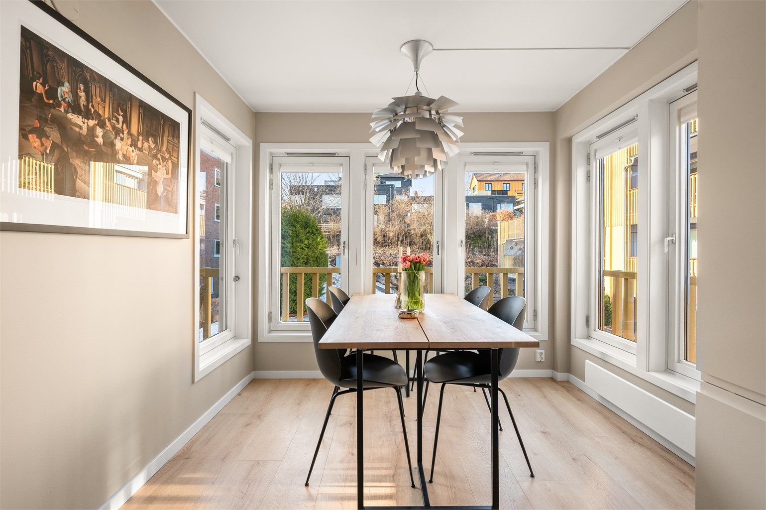 Spisestuen er plassert i et lyst hjørne med vinduer som slipper inn rikelig med dagslys.