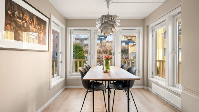 Spisestuen er plassert i et lyst hjørne med vinduer som slipper inn rikelig med dagslys.