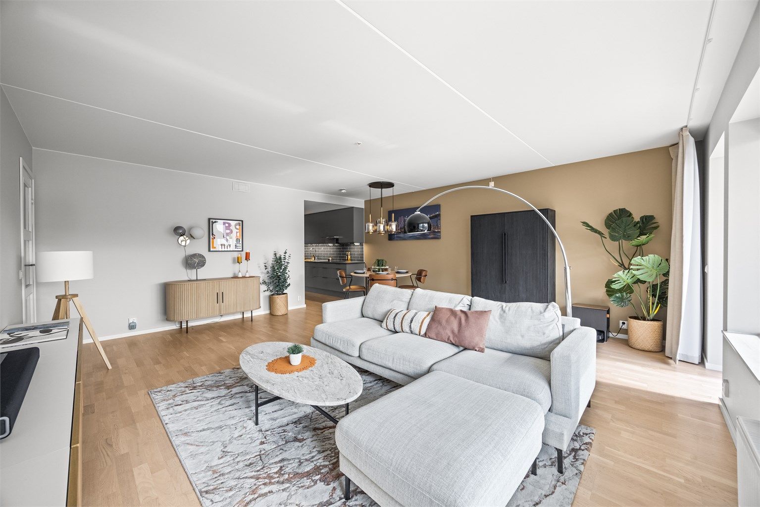Den åpne stue- og kjøkkenløsningen gir god plass til både sofagruppe og spisebord.