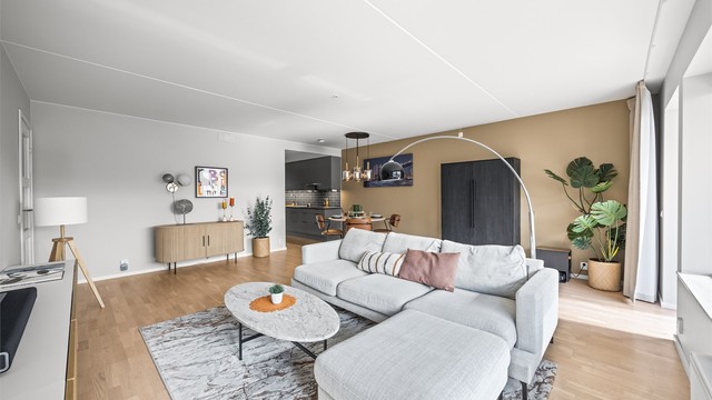 Den åpne stue- og kjøkkenløsningen gir god plass til både sofagruppe og spisebord.