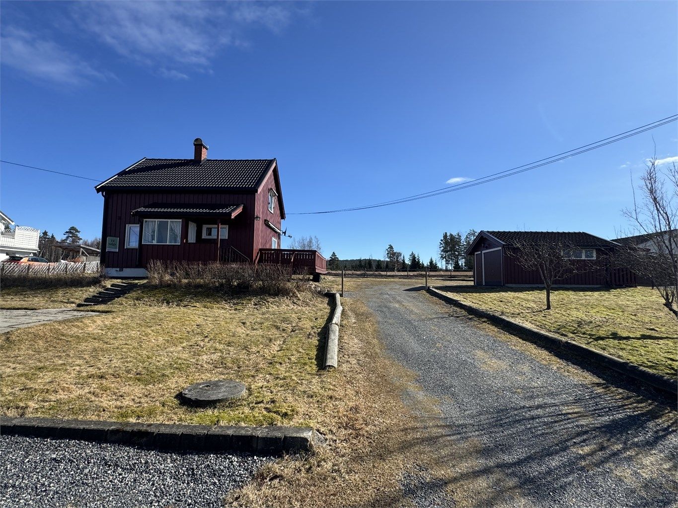 Boligen har en klassisk fasade med stående trekledning.