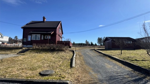 Boligen har en klassisk fasade med stående trekledning.