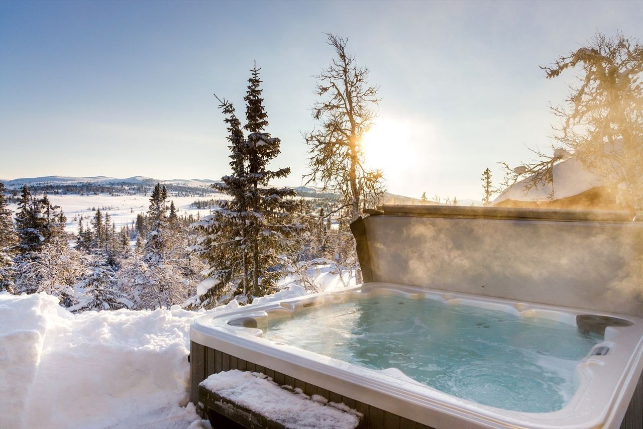 Etter en lang dag i fjellet kan du senke deg ned i den oppvarmede jacuzzien med utsikt over landskapet.