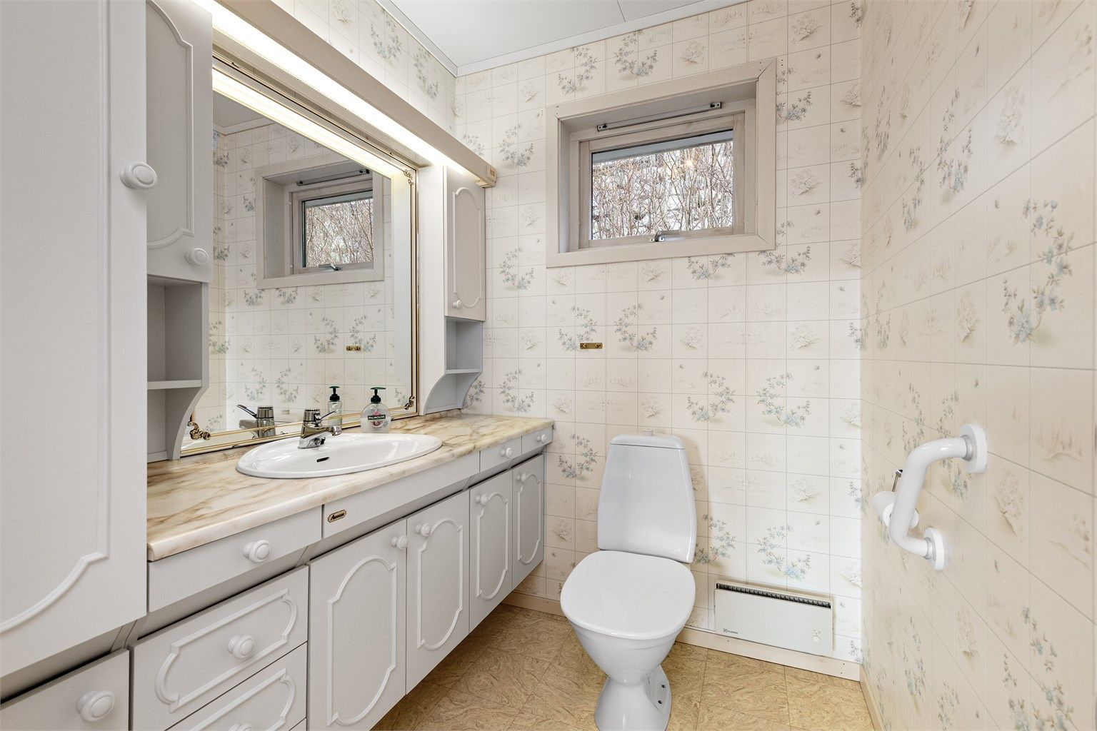 Badet i underetasjen er fra byggeåret og har epoxybelegg på gulv, dusjnisje og toalett