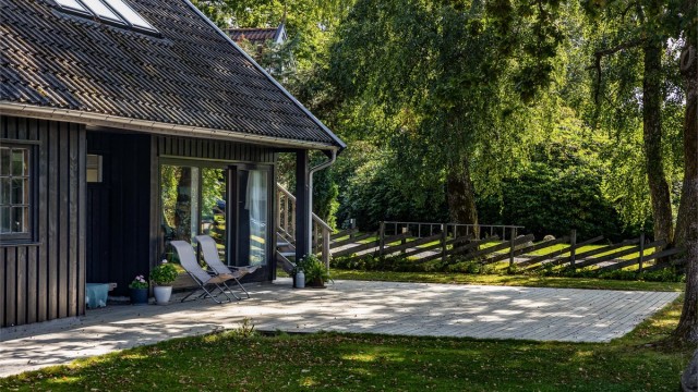 Velvoksne trær og grønne prydbusker gir hagen et frodig uttrykk.
