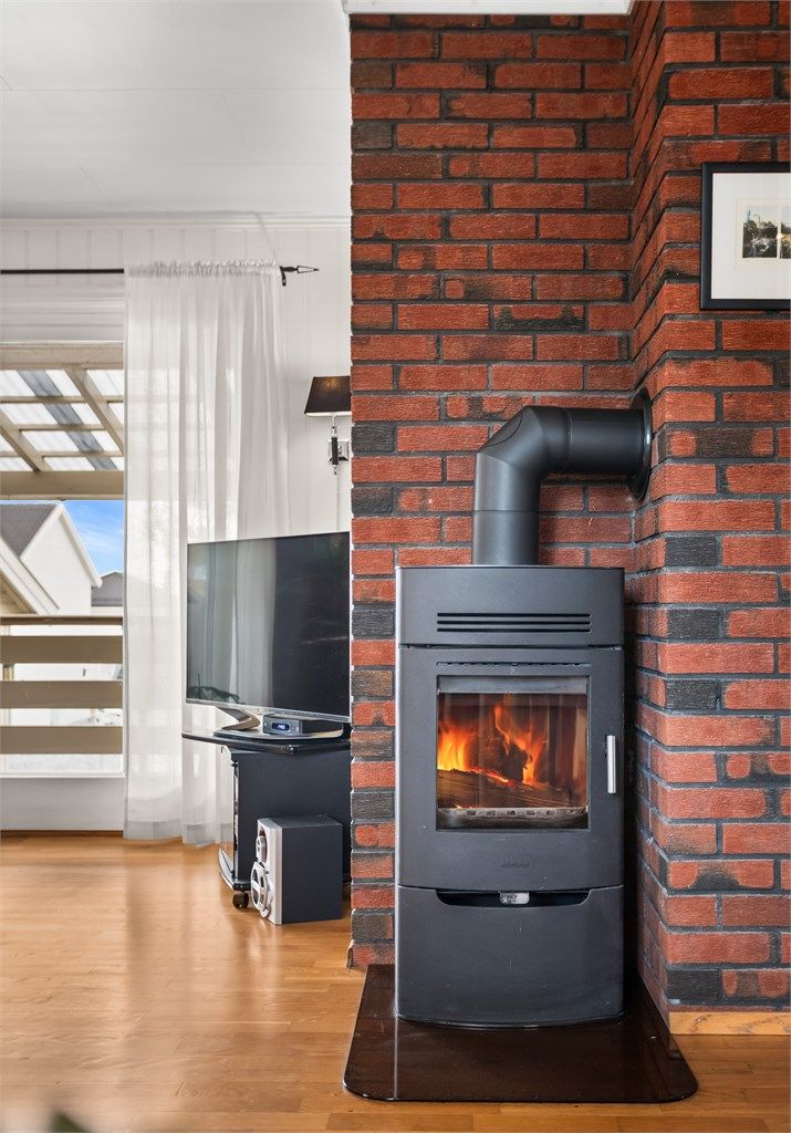 Peisovnen er plassert sentralt i rommet, med en omramming av teglstein.