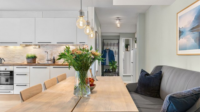 Fra spiseplassen er det kort vei til både kjøkkenbenken og sofakroken, noe som understreker den gjennomtenkte planløsningen.