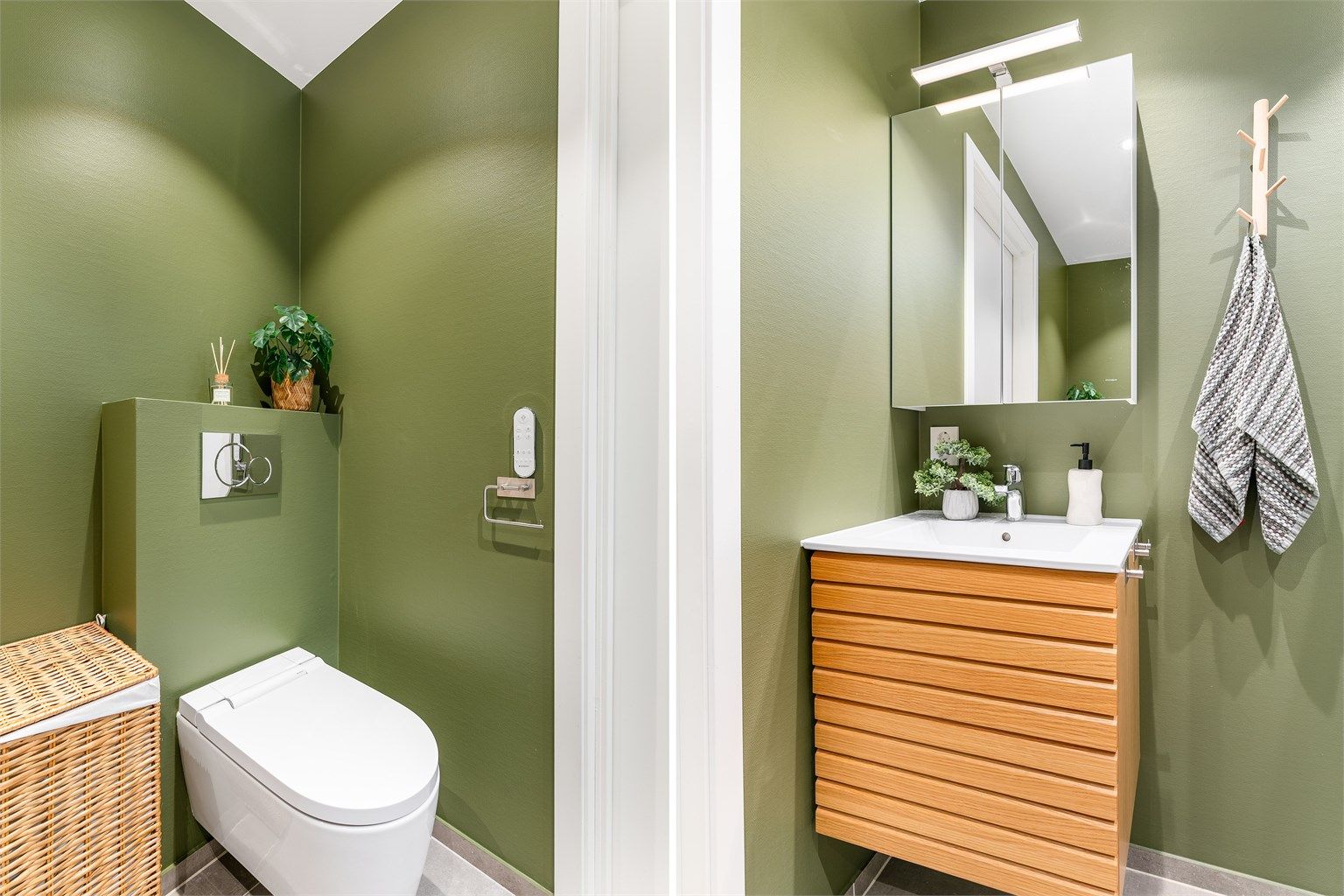 Baderomsmøblene har oppbevaringsplass i både servantskuffer og speilskap. Toalettet har spylefunksjon.