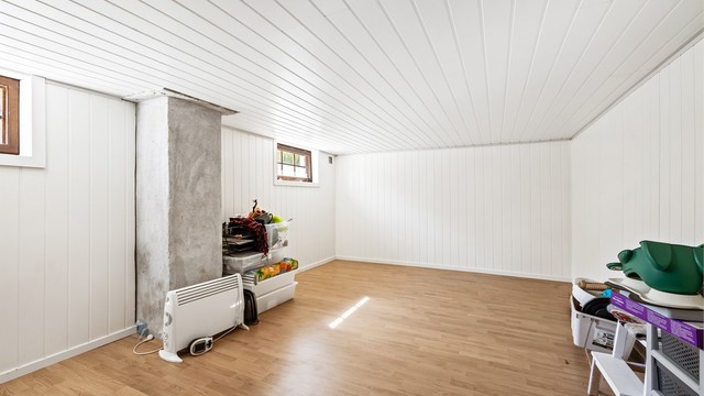 Innredet kjellerstue i kjelleren med laminatgulv og panelplater på veggene. Rommet er ikke byggemeldt.