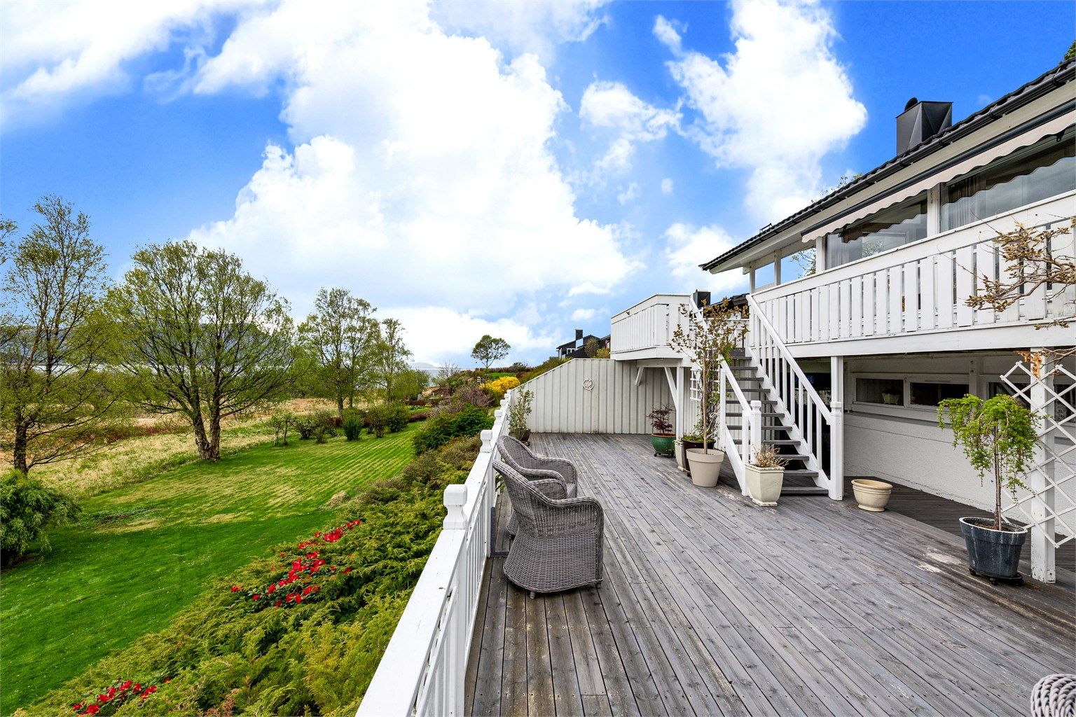 Fra den øvre terrassen fører en trapp ned til en enda større treterrasse på bakkeplan på 62 kvm