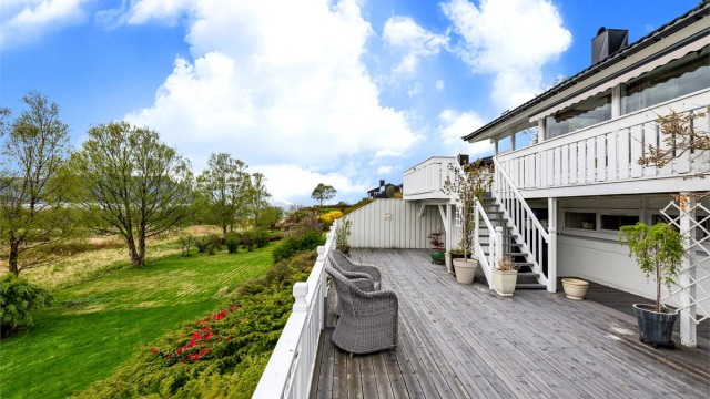 Fra den øvre terrassen fører en trapp ned til en enda større treterrasse på bakkeplan på 62 kvm