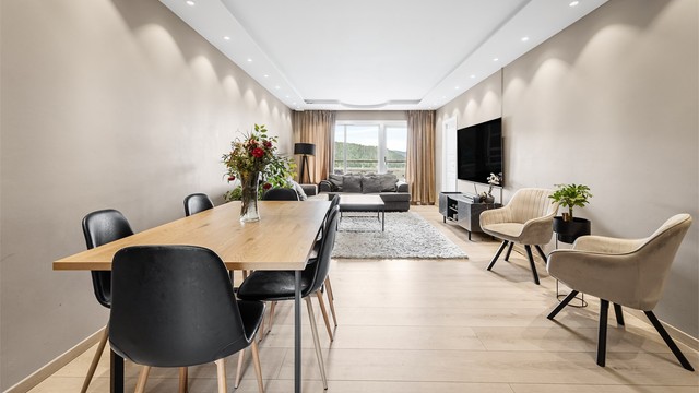 Lys og lun stue med sofaområde, sittegruppe samt spiseplass.