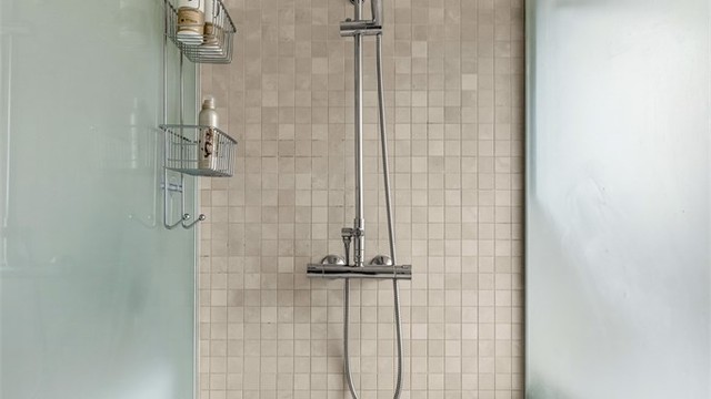 Romslig dusjnisje med regnfallsdusj.