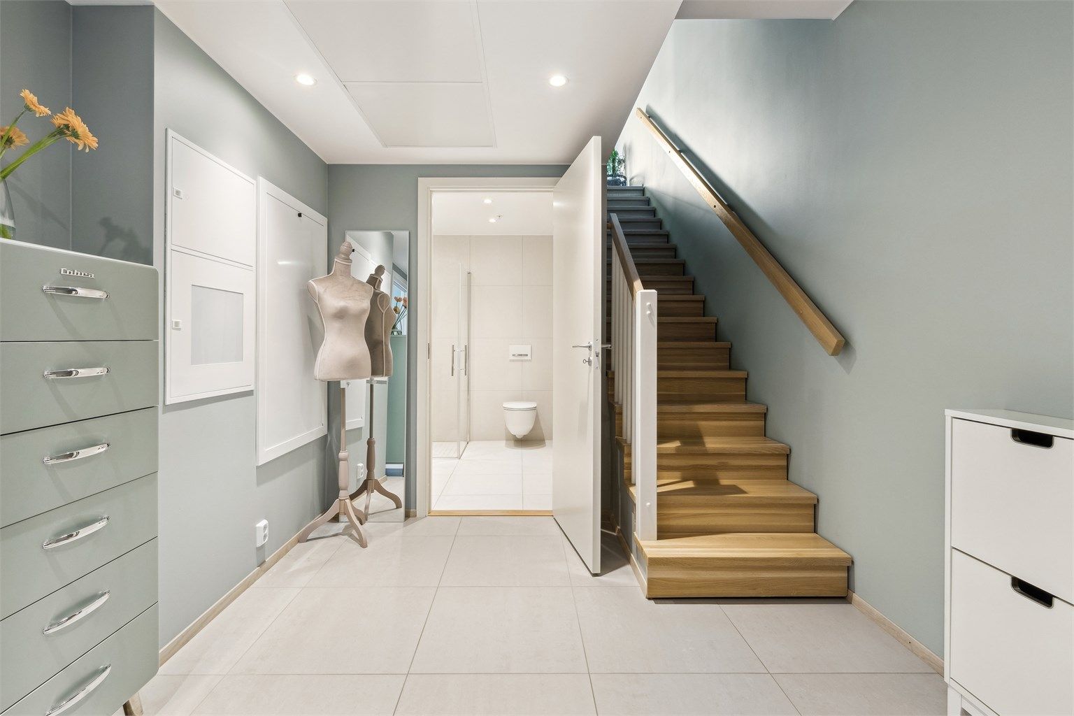 Velkommen inn i en romslig, lys og flislagt entré med videre adkomst til stue/kjøkken, bad og trapp opp til 2. etasje.