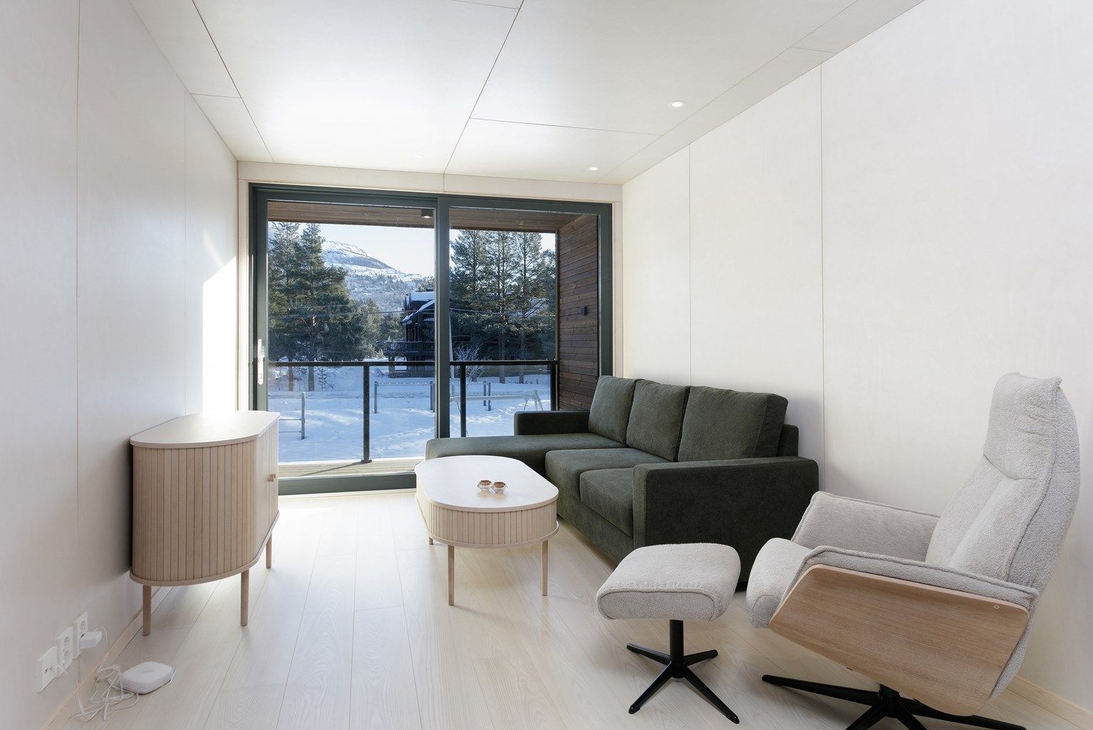 Det er utgang fra stue til inntrukket balkong med glassrekkverk