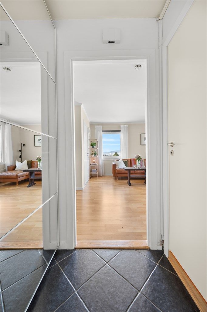 Velkommen inn. Gulvet i entréen er flislagt, og praktisk skyvedørsgarderobe er montert.