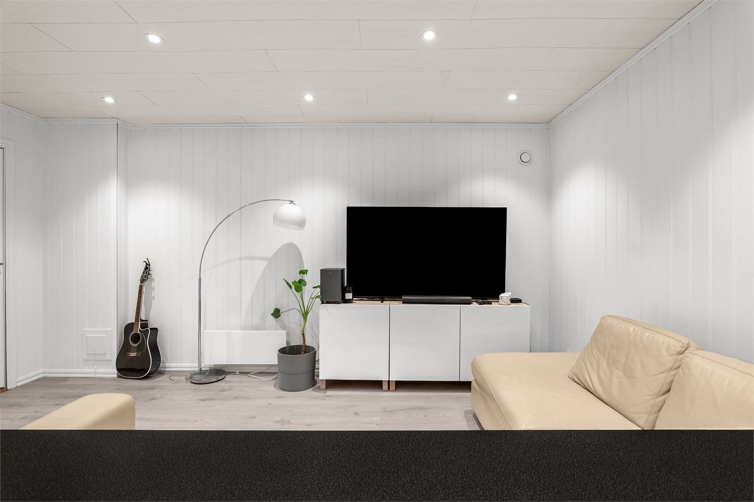 Hyggelig og innbydende stue med naturlig TV-sone, god plass til møblering og belysning fra downlights i taket.