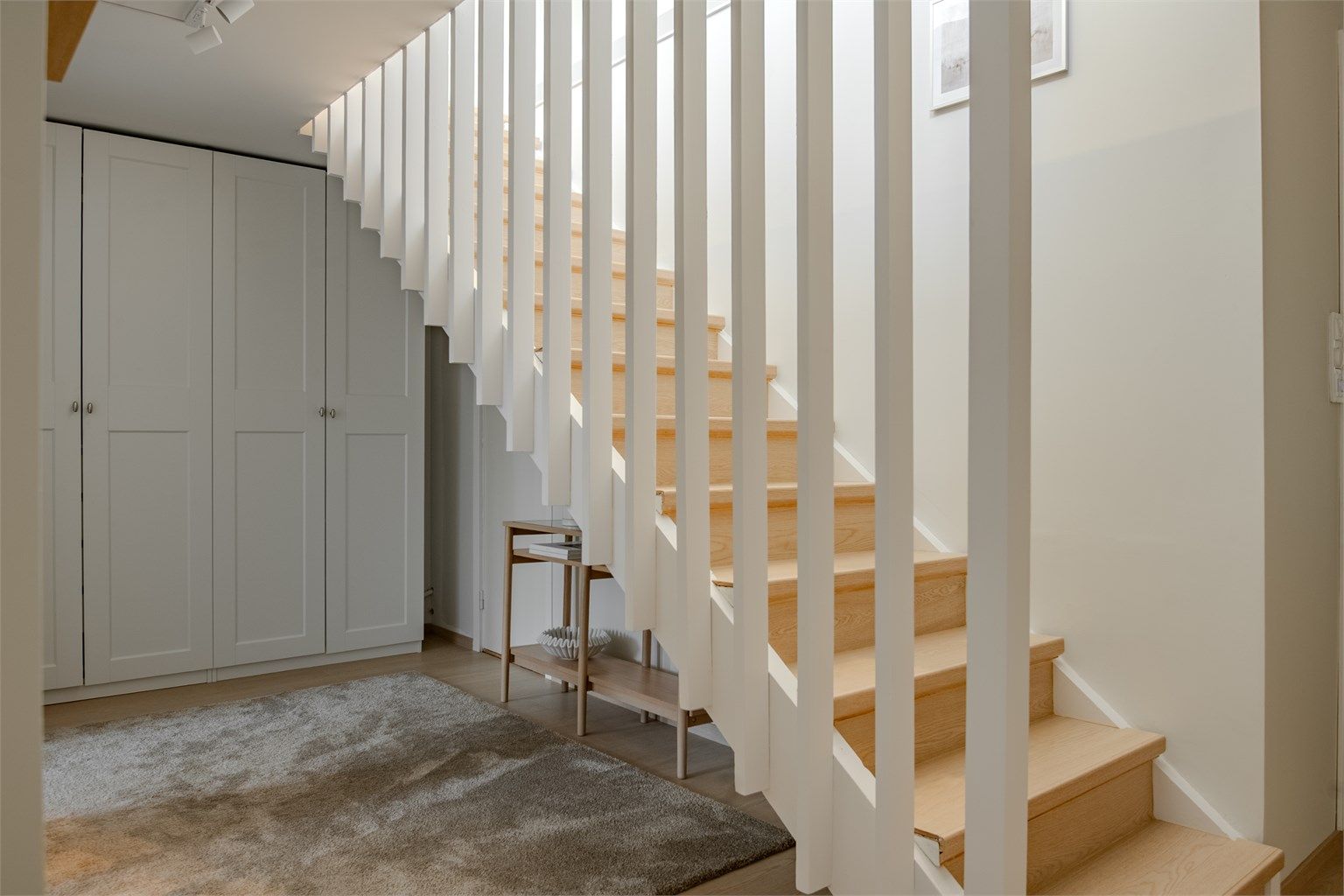 Innvendig trapp i tre med spilerekkverk forbinder de to etasjene. Under trappen er det god plass til oppbevaring.