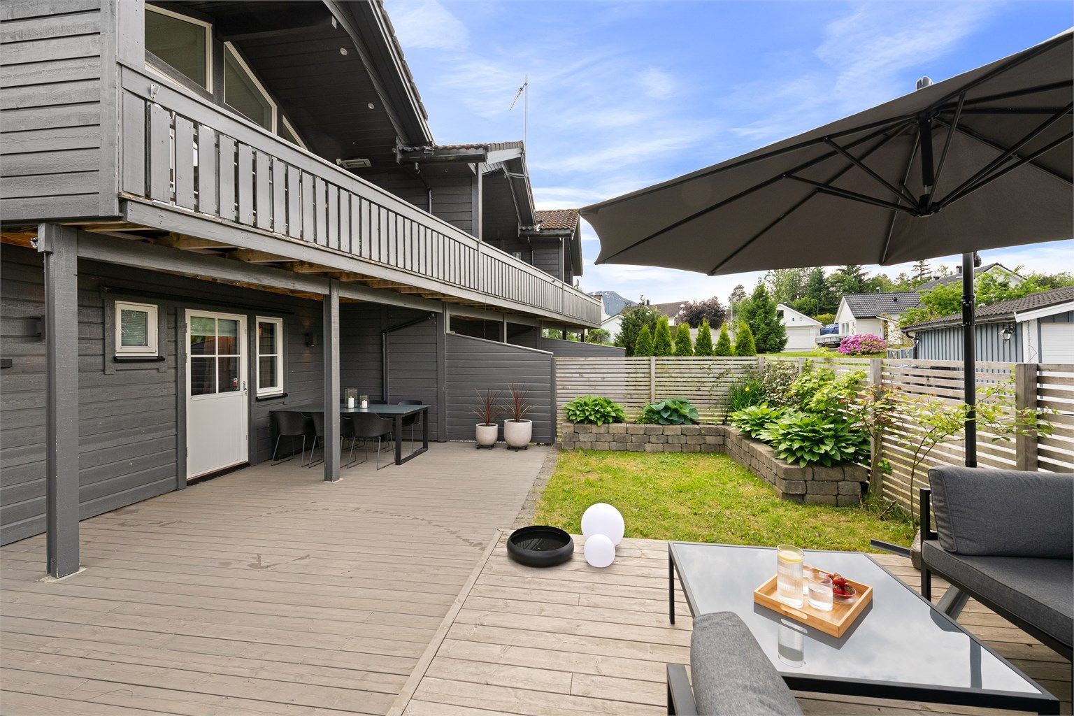 Stor, nordvestvendt markterrasse med flere soner for utemøbler og lek.
