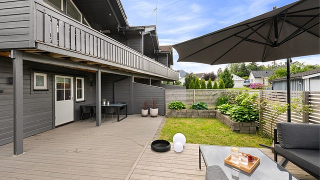 Stor, nordvestvendt markterrasse med flere soner for utemøbler og lek.