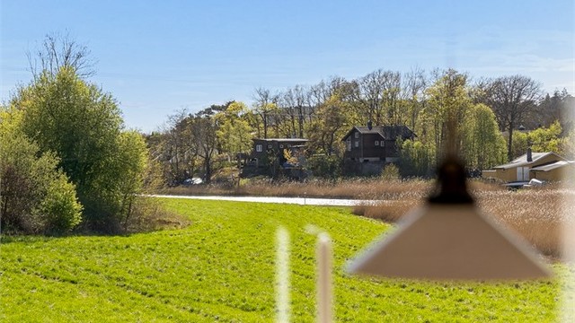 Utsikt fra vinduet i stuen ned til sjøen og de landlige omgivelsene.