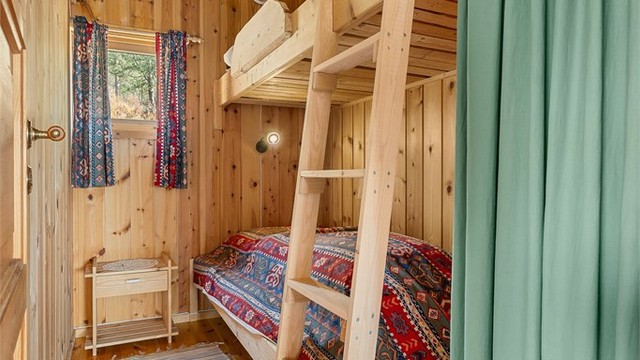 Koselig soverom på 4 kvm med smart utnyttelse av plassen og klassisk hyttestil.