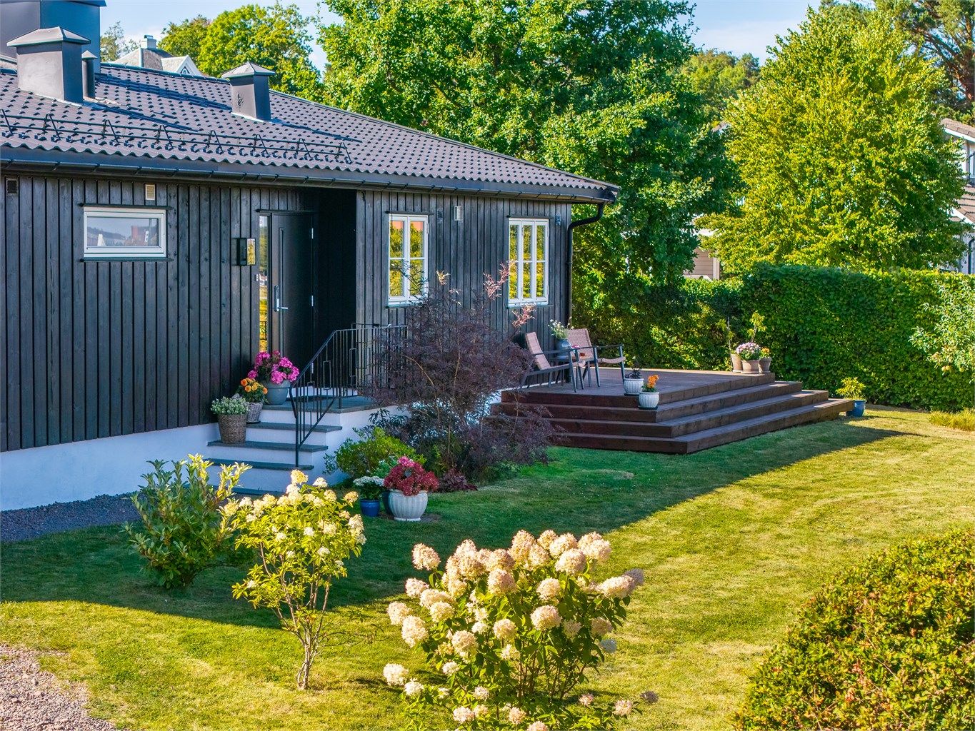 Tomten er pent opparbeidet med plen, beplantning, frukttrær og bærbusker.