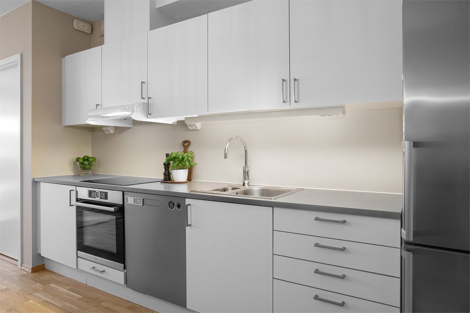 Sigdal kjøkkeninnredning med lyse glatte fronter - hvitevarene følger med. 