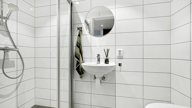 Badet har servant, vegghengt toalett og elektrisk gulvvarme.