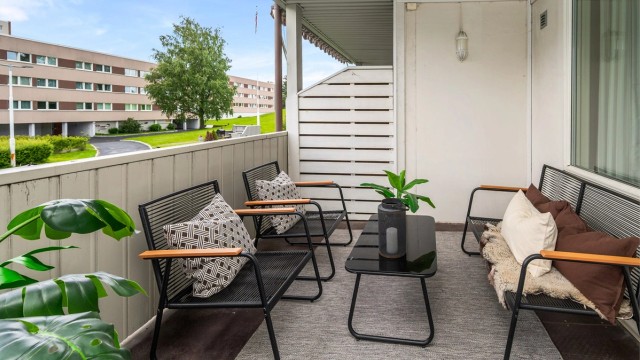 Overbygget balkong som gir en lun og skjermet uteplass med god plass til sittegruppe.