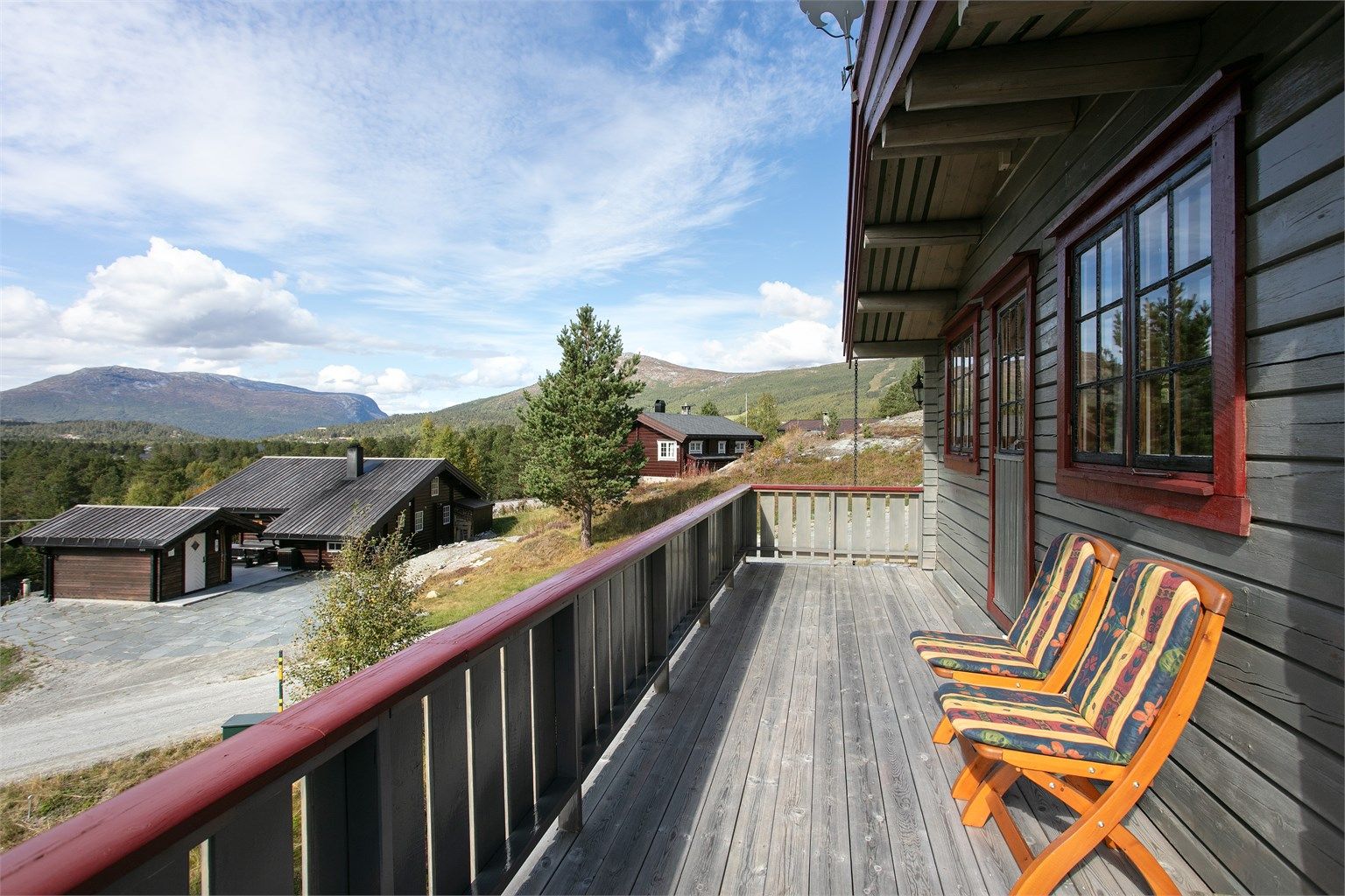 Terrassen byr på åpen utsikt mot omkringliggende fjell og natur.