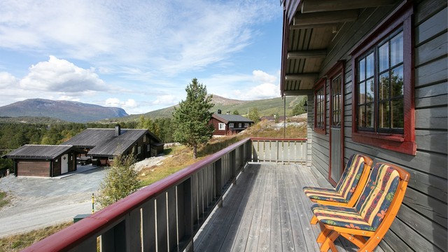 Terrassen byr på åpen utsikt mot omkringliggende fjell og natur.