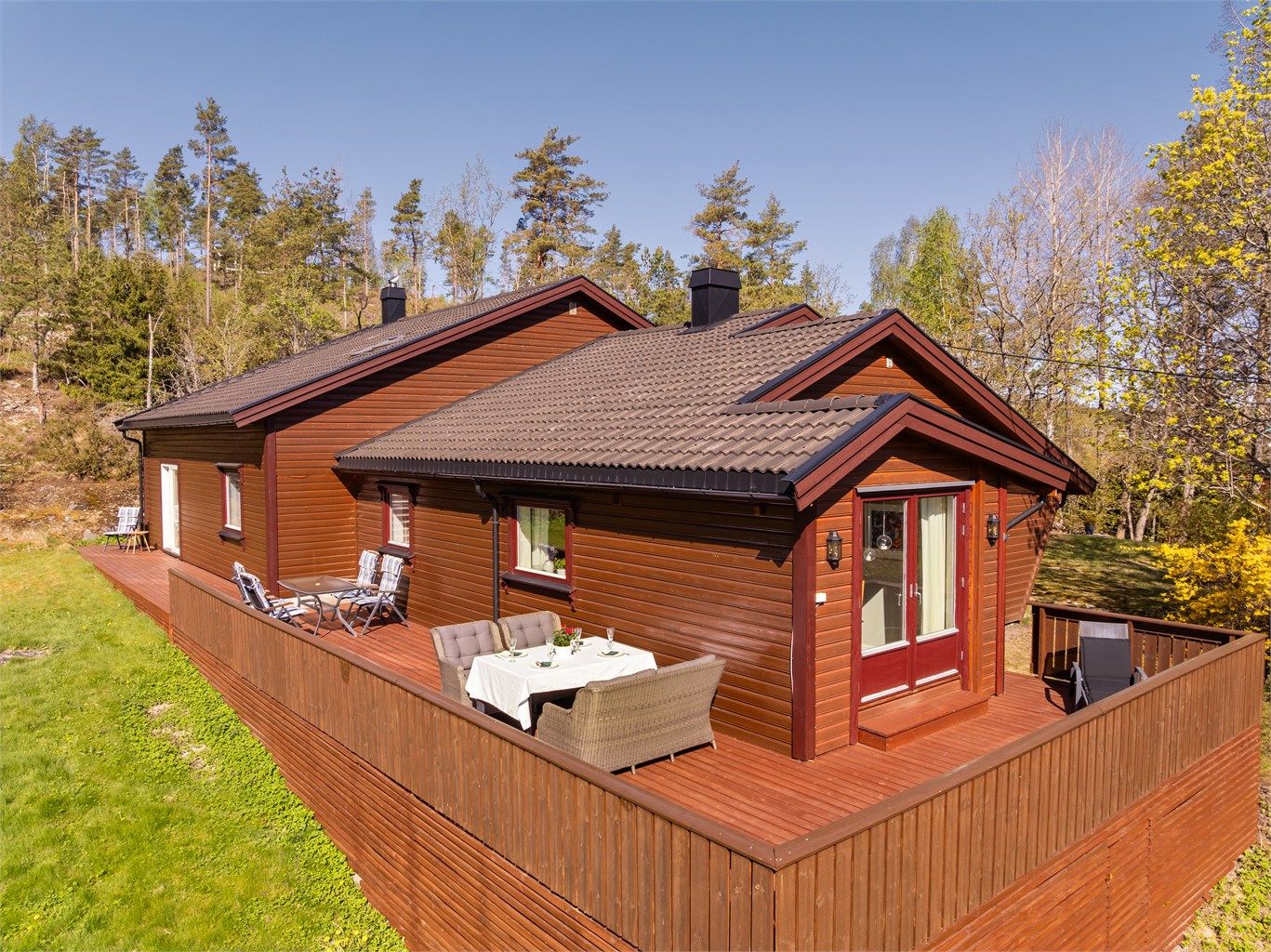 Stor terrasse ble oppført rundt boligens øst fra 2001- og sørside som omfatter tilbygget så nylig som i 2020. Beis i samme nyanse som kledningen skaper et meget helhetlig uttrykk.