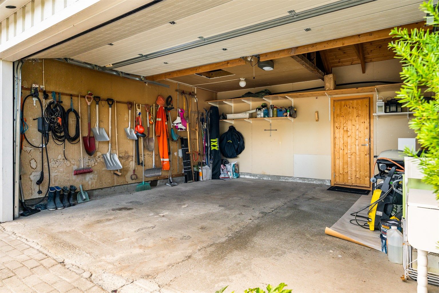 Det er etablert en dobbeltgarasje med elbillader i tillegg til flere biloppstillingsplasser på tomten. Boden i bakkant måler romslige 9 kvm og har gode oppbevaringsmuligheter. 