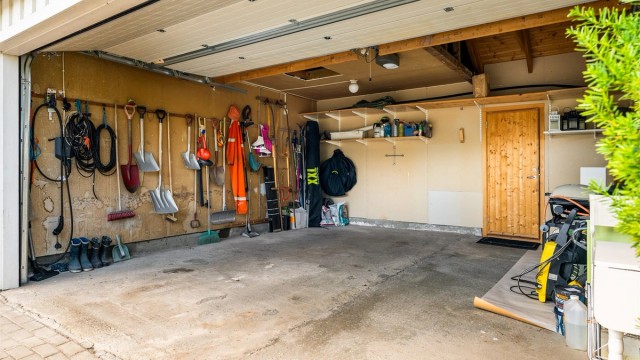 Det er etablert en dobbeltgarasje med elbillader i tillegg til flere biloppstillingsplasser på tomten. Boden i bakkant måler romslige 9 kvm og har gode oppbevaringsmuligheter.