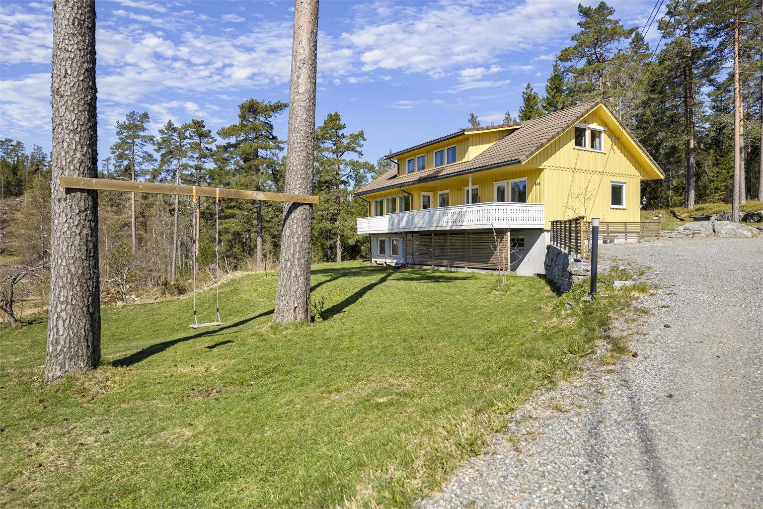 En innholdsrik enebolig over tre plan med stor hage og dobbelgarasje, perfekt for en aktiv familie.