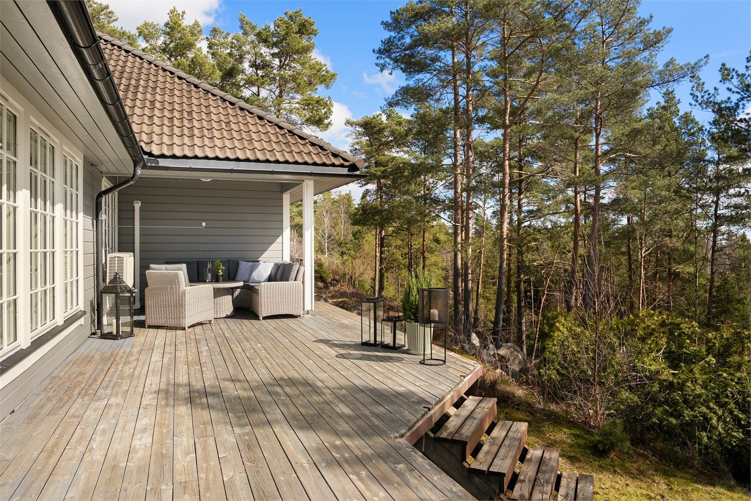 I kroken under taket innerst på terrassen er det lun og hyggelig å sitte ute også på lyse sommerkvelder - helt usjenert.