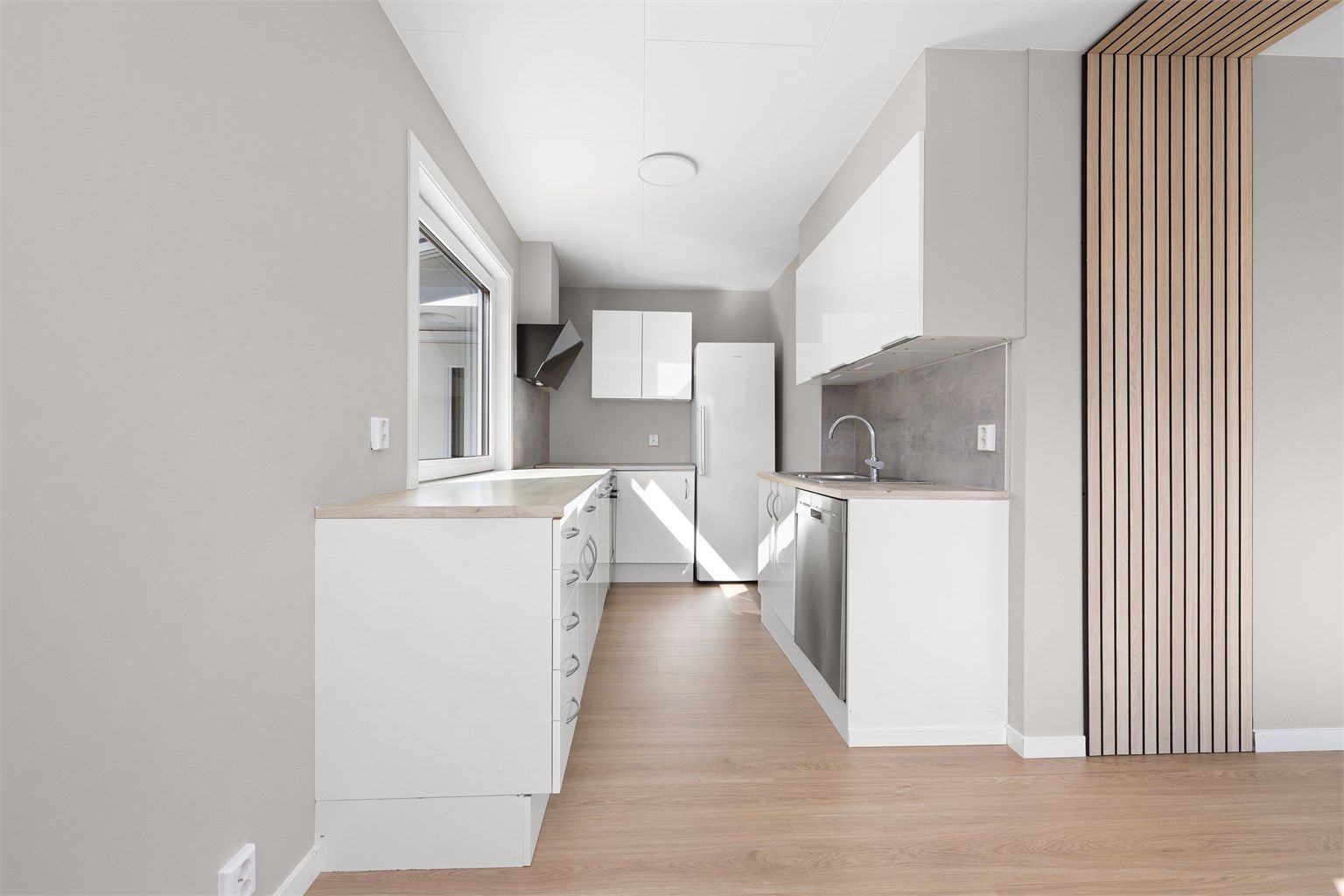 Kjøkkeninnredning fra IKEA med glatte fronter og laminat benkeplate.